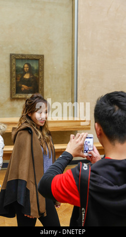 L'uomo prendendo foto della donna di fronte Dipinto La Gioconda di Leonardo da Vinci, il museo del Louvre, Parigi, Francia Foto Stock