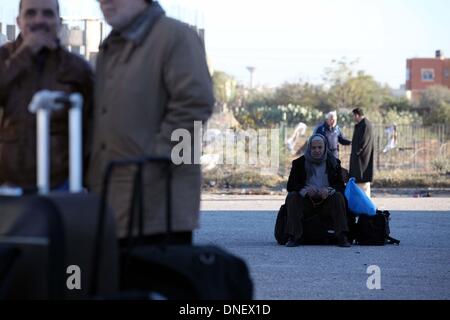 La striscia di Gaza, Territori palestinesi. 24 dicembre, 2013. Un uomo palestinese si siede sul suo bagaglio come egli attende a Rafah varcare il confine tra Egitto e il sud della striscia di Gaza il 24 dicembre 2013. Le autorità egiziane parzialmente aperto valico di Rafah, la striscia di Gaza è la finestra principale per il mondo e per tre giorni per casi umanitari e gli studenti a filamento, dei funzionari di confine detto.Foto: Moemen Faiz/NurPhoto Credito: Moemen Faiz/NurPhoto/ZUMAPRESS.com/Alamy Live News Foto Stock