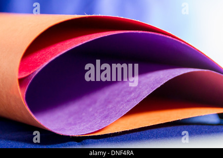 Close-up di multi carta colorata con sfondo blu Foto Stock