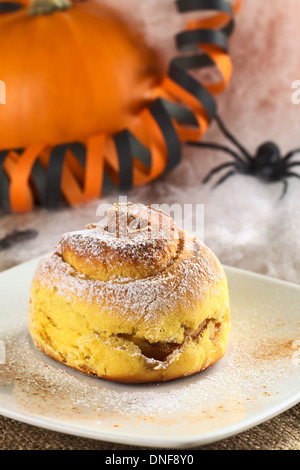 La zucca cinnamon roll guarnita con zucchero al velo e cannella, Decorazione Halloween nella parte posteriore Foto Stock