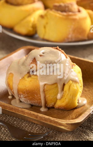 La zucca cinnamon roll con cannella ciliegina sulla sommità (il fuoco selettivo, la messa a fuoco sul bordo anteriore destro del rullo) Foto Stock