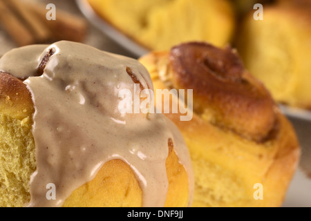 La zucca cinnamon roll con glassa di cannella (messa a fuoco selettiva, messa a fuoco sulla parte anteriore del bordo superiore del rullo e il ghiaccio) Foto Stock