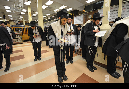 Ebrea ortodossa gli uomini alla mattina dei giorni feriali preghiere indossando tefillin - phylacteries - Preghiera e scialli. Crown Heights, Brooklyn, NY Foto Stock