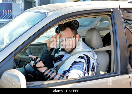 Ritratto di una religiosa ebraica l uomo nella sua auto indossando phylacteries, cranio cap & preghiera scialle. In Crown Heights, Brooklyn, New York. Foto Stock