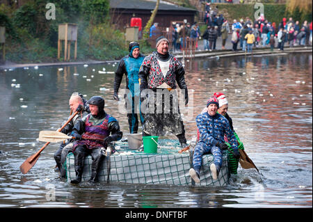 L annuale Boxing Day Raft Race (2013) sul fiume Derwent tra Matlock e Cromford, Derbyshire, Regno Unito. Spettatori pelt zattere con farina e bombe zattera racers ritorsione con acqua in cestelli e dai tubi flessibili. Foto Stock