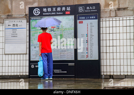 Pechino Cina, cinese, stazione della metropolitana di Wangfujing, linea 1, Asian teen teenager teenagers ragazzo ragazzi maschio bambini ombrello, meteo, ingresso, uscita, Foto Stock