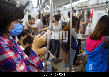 Pechino Cina, cinese, stazione della metropolitana Dongsi, linea 5 6, cabina del treno, adulti asiatici, donne donne, passeggeri passeggeri motociclisti, rider, smartph Foto Stock