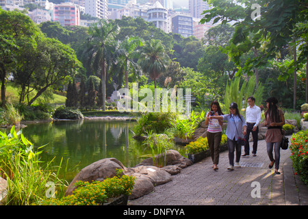 Hong Kong Cina,Hong Kong,Asia,cinese,orientale,isola,centrale,Hong Kong Park,paesaggio,alberi,stagno,adulti asiatici,donne donne donne,amici,skyline della città Foto Stock