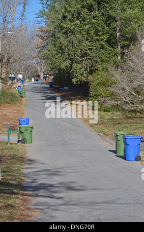 Un quartiere street foderato con cestino di riciclaggio e contenitori pronti per il ritiro Foto Stock