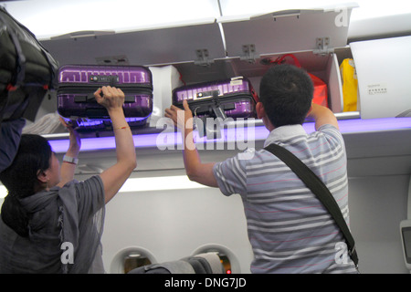 Hong Kong Cina,HK,Asia,Cinese,Orientale,Aeroporto Internazionale di Hong Kong,HKG,uomo asiatico uomo maschio,adulto,adulti,donna donna donne,trasporto bagagli in rimozione Foto Stock