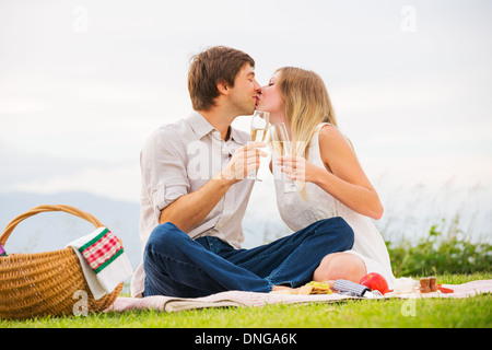 Coppia attraente kissing sul pomeriggio romantico picnic in campagna Foto Stock