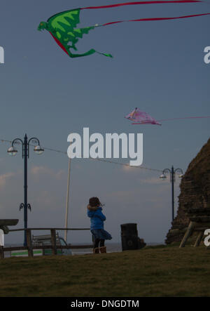 Aberystwyth, Wales, Regno Unito. Il 27 dicembre 2013. Un giovane bambino prende vantaggio dei venti di tempesta a volare il loro aquilone. Credito: Jon Freeman/Alamy Live News Foto Stock