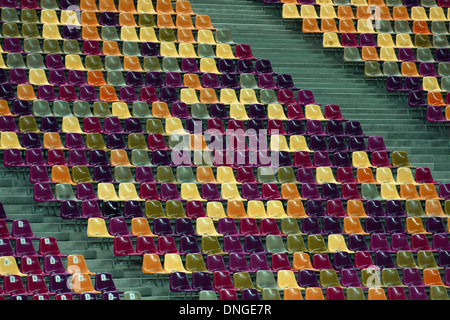 Righe di sedi vuote di colori differenti in un Stadium Foto Stock