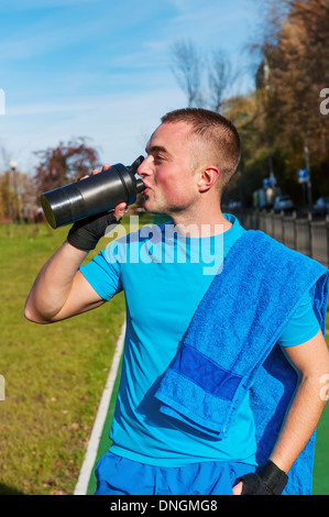 Giovane uomo acqua potabile dopo allenamento Foto Stock