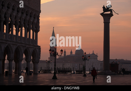 Vista sunrise vuoti di piazza San Marco a Venezia il cielo arancione e San Giorgio Maggiore sfondo silhouette Foto Stock