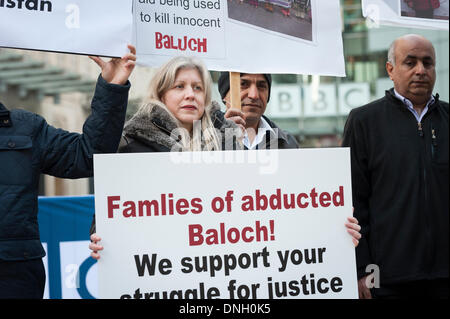 Portland Place, Londra, Regno Unito . 29 Dic, 2013. Un gruppo di dimostranti si riuniscono al di fuori di BBC Broadcasting House a sostegno di un costante marcia di protesta che coprono oltre 1500km in Pakistan. Gli attivisti rivendicazione di migliaia di persone sono state recentemente detenuti o scomparsi nel Balochistan da agenzie di sicurezza ancora la BBC ha dedicato scarsa copertura mediatica di eventi. Credito: Lee Thomas/Alamy Live News Foto Stock