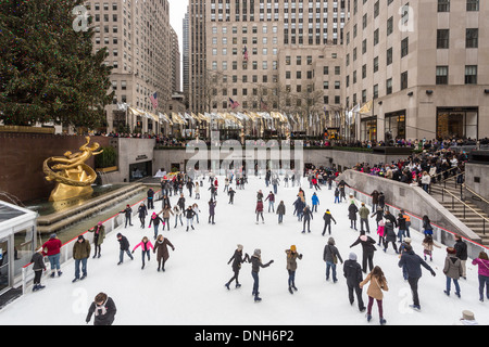 Una folla di pattinatori godendo di pattinaggio sul ghiaccio al Concourse al Rockefeller Center di New York, Stati Uniti d'America in inverno Foto Stock