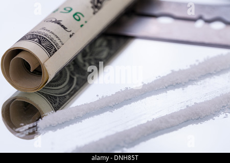 Linee di cocaina sullo specchio con una lama di rasoio farmaci oggetti macro closeup Foto Stock