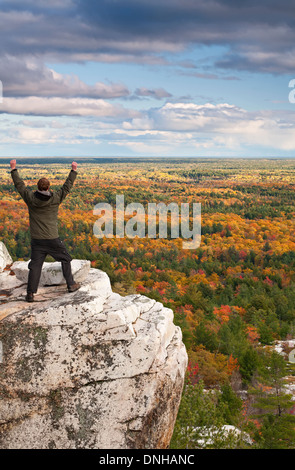 Un escursionista mostra la sua emozione sul bordo di una scogliera a Killarney Provincial Park, Ontario, Canada. Foto Stock