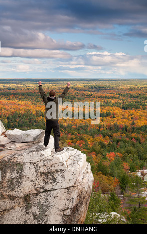 Un escursionista mostra la sua emozione sul bordo di una scogliera a Killarney Provincial Park, Ontario, Canada. Foto Stock