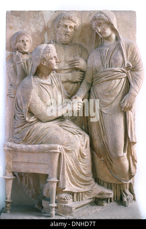 Stretta di mano o il messaggio di saluto Dexiosis Bas-Relief sul Greco antico sepolcro di pietra o di sarcofago con il defunto seduto e mia moglie (C340BC) Atene Grecia Foto Stock