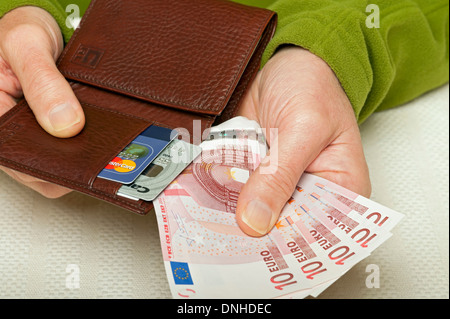 Primo piano di mani uomo persona che detiene 10 euro Banconote in denaro europeo banconote banconote in banconote e portafogli in pelle Europa UE Foto Stock