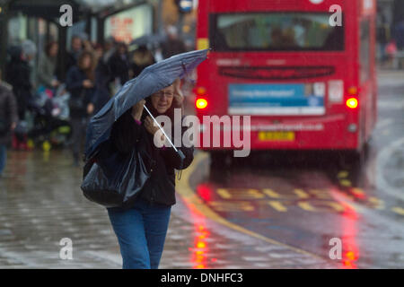 Il torneo di Wimbledon di Londra, UK . Il 30 dicembre 2013. Gli acquirenti e i " commuters " lotta per far fronte con il tempo umido a Wimbledon centro città come gale force al vento fino a 80mph e heavy rain ha colpito molte parti del Regno Unito Credito: amer ghazzal/Alamy Live News Foto Stock