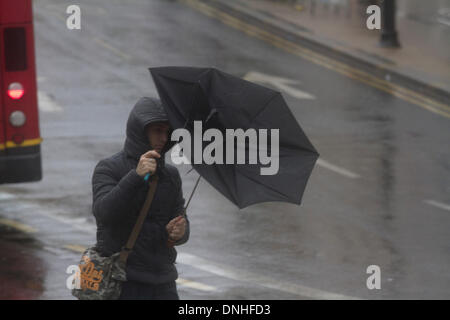 Il torneo di Wimbledon di Londra, UK . Il 30 dicembre 2013. Gli acquirenti e i " commuters " lotta per far fronte con il tempo umido a Wimbledon centro città come gale force al vento fino a 80mph e heavy rain ha colpito molte parti del Regno Unito Credito: amer ghazzal/Alamy Live News Foto Stock