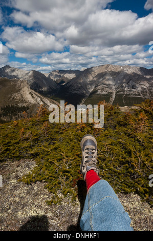 Escursionista femmina in appoggio sulla sommità di una catena montuosa. Montagne Rocciose Canadesi Foto Stock