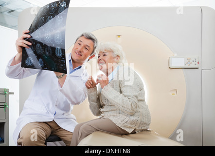 Il medico e il paziente guardando la scansione TC X-ray Foto Stock