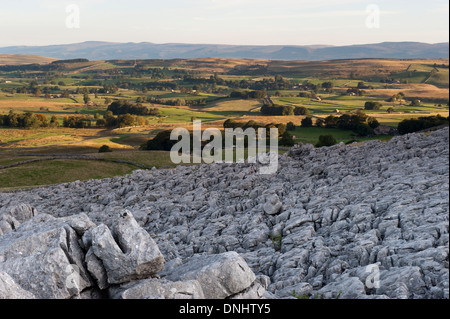 Alba sulle estremità cadde nuvole, , una zona di pavimentazione di pietra calcarea, guardando verso l'Eden Valley in Cumbria, nel Regno Unito. Foto Stock