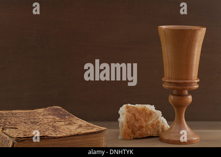 Comunione in legno cup, pane e pelle vintage legato la Bibbia. Foto Stock