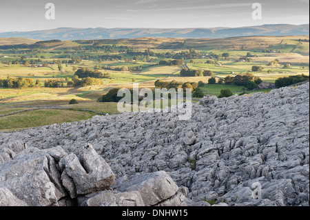 Alba sulle estremità cadde nuvole, , una zona di pavimentazione di pietra calcarea, guardando verso l'Eden Valley in Cumbria, nel Regno Unito. Foto Stock