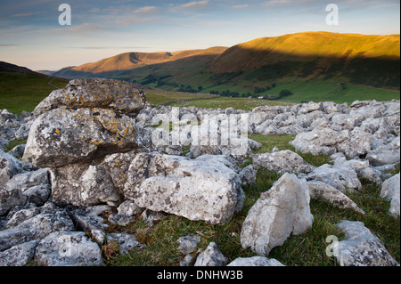 Alba sulle estremità cadde nuvole, , una zona di pavimentazione di pietra calcarea, guardando verso la Howgill Fells in Cumbria, nel Regno Unito. Foto Stock