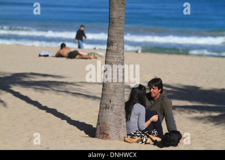 Giovane uomo e donna sotto l albero di palme sulla spiaggia di Ft. Lauderdale, Florida. Foto Stock