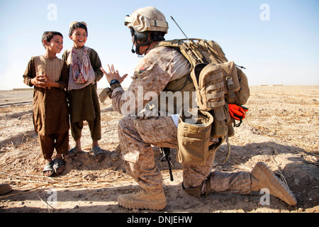 Un marine statunitense scherzi circa con bambini afgani durante un funzionamento Luglio 3, 2013 nella provincia di Helmand, Afghanistan. Foto Stock