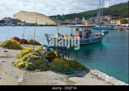 Fisherman riassettavano le reti nel porto di Fiscardo, Cefalonia, Grecia Foto Stock