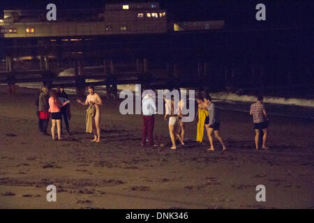 Aberystwyth, Wales, Regno Unito. Il 1 gennaio 2014. A tarda notte striscia di festaioli off per una nuotata per festeggiare il nuovo anno in Aberystwyth. Credito: Jon Freeman/Alamy Live News Foto Stock