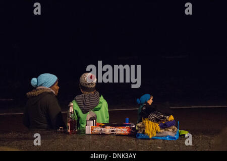 Aberystwyth, Wales, Regno Unito. Il 1 gennaio 2014. Il veglione di Capodanno sulla spiaggia di Aberystwyth con rosa vino spumante e fuochi d'artificio Credito: Jon Freeman/Alamy Live News Foto Stock