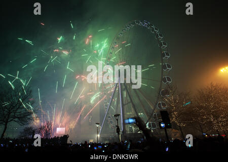 Festeggiamenti di buon anno come la folla godere di giostre di divertimento con luci a Manchester, Regno Unito gennaio, 2014. Quest'anno, per la prima volta, i Piccadilly Gardens hanno ospitato le celebrazioni di Capodanno e i fuochi d'artificio sponsorizzati privatamente da Manchester. L'evento ha caratterizzato un'esposizione di fuochi d'artificio di 10 minuti, ruota di ferro, parco, divertimento, cielo, divertimento, divertimento, viaggi, città, carnevale, fiera, giro, blu, giostra, attrazione, tempo libero, festival, cerchio notturno. La vigilia di Capodanno gira sulla ruota grande con un'altezza di 60m, 42 pod spinning fino al 1am. Foto Stock