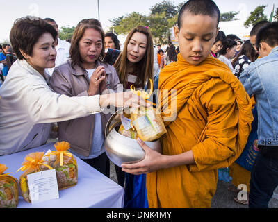 Bangkok, Tailandia. 1a gen, 2014. Le persone a rendere merito mediante la presentazione di offerte per i monaci buddisti a Bangkok City Hall. Diverse migliaia di persone, soprattutto Bangkok city funzionari, si sono radunati nella piazza della Città di Bangkok Hall Mercoledì per il tradizionale nuovo anno rendendo merito cerimonia. Credito: ZUMA Press, Inc./Alamy Live News Foto Stock