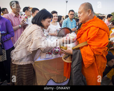 Bangkok, Tailandia. 1a gen, 2014. Le persone a rendere merito mediante la presentazione di offerte per i monaci buddisti a Bangkok City Hall. Diverse migliaia di persone, soprattutto Bangkok city funzionari, si sono radunati nella piazza della Città di Bangkok Hall Mercoledì per il tradizionale nuovo anno rendendo merito cerimonia. Credito: ZUMA Press, Inc./Alamy Live News Foto Stock