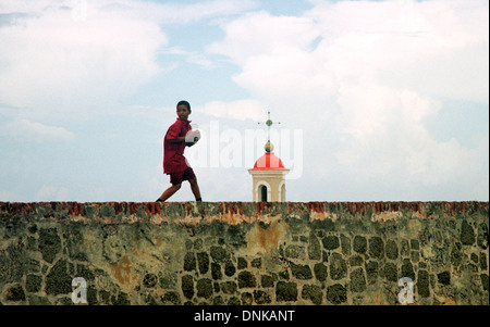 Un bambino gioca su una parete esterna del Forte Spagnolo San Felipe del Morro nella vecchia San Juan, Puerto Rico. 2001. Foto Stock