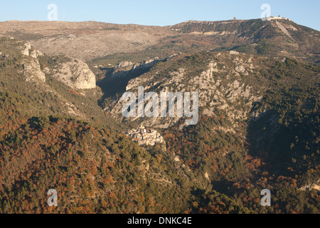 VISTA AEREA. Arroccato borgo medievale in un ambiente naturale, Mont-Agel in lontananza. Peillon, Alpes-Maritimes, il backcountry della Costa Azzurra, Francia. Foto Stock