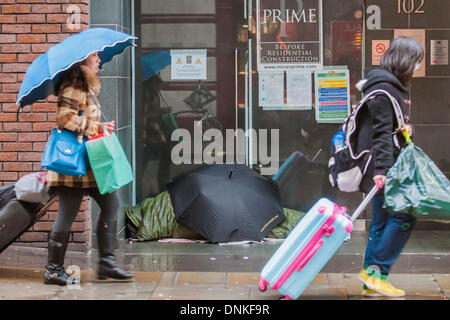 Londra, Regno Unito. 01 gen 2014. Un nuovo anno di parata del giorno passa attraverso Piccadilly Circus su un umido e ventoso giorno. Tra i vicoli di post Natale e Anno Nuovo i rifiuti di pile e homless persone vengono ignorate dai visitatori caricato verso il basso dai sacchetti. Londra, UK 01 Jan 2014. Credito: Guy Bell/Alamy Live News Foto Stock