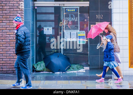 Londra, Regno Unito. 01 gen 2014. Un nuovo anno di parata del giorno passa attraverso Piccadilly Circus su un umido e ventoso giorno. Tra i vicoli di post Natale e Anno Nuovo i rifiuti di pile e homless persone vengono ignorate dai visitatori caricato verso il basso dai sacchetti. Londra, UK 01 Jan 2014. Credito: Guy Bell/Alamy Live News Foto Stock