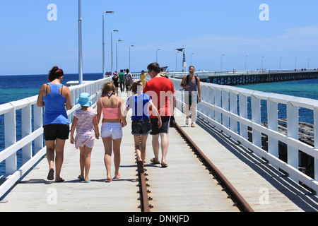 Una fotografia di una famiglia a piedi lungo Busselton Pier (molo) vicino a Perth in Australia Occidentale. Foto Stock