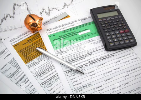 Lucidare le imposte sul reddito dei moduli con calcolatrice e piggybank Foto Stock