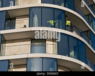 Lavoratori edili mettendo tocchi di rifinitura e controllo di appartamenti di lusso dalla Torre di Londra, Inghilterra, Regno Unito Foto Stock
