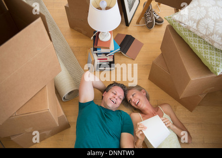 Giovane giacente sul piano della nuova casa Foto Stock